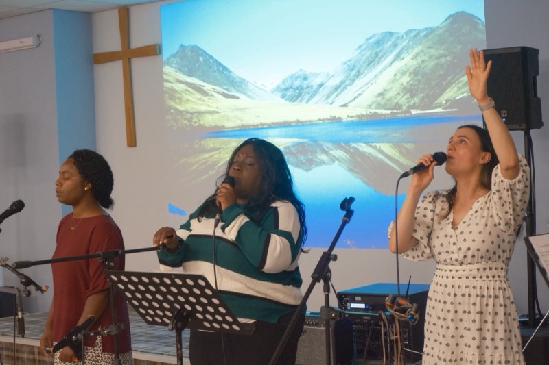 Worship leaders singing with hands raised